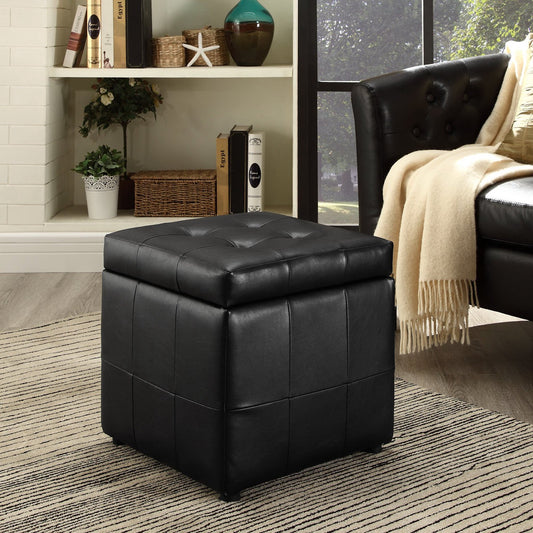 Black leather ottoman in a living room setting with a couch and decor items.