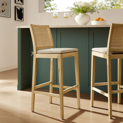 Wooden bar stools with cushioned seats in a kitchen setting.